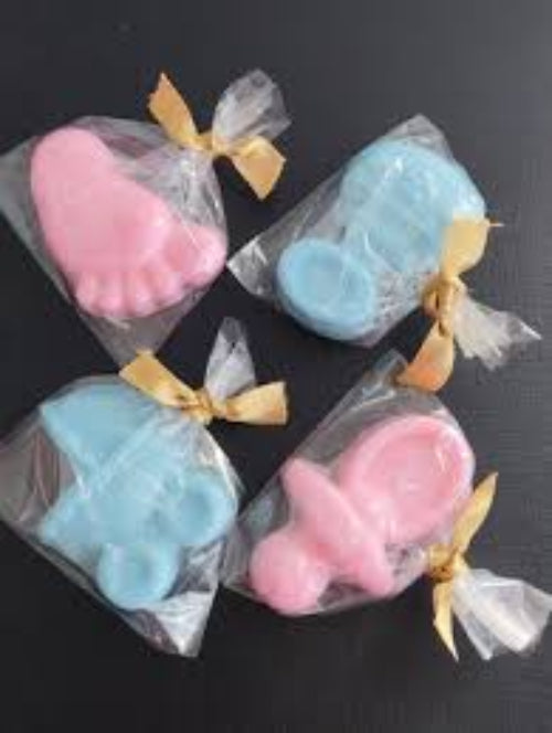 Three small, colorful soap-like objects with ribbons on a black background