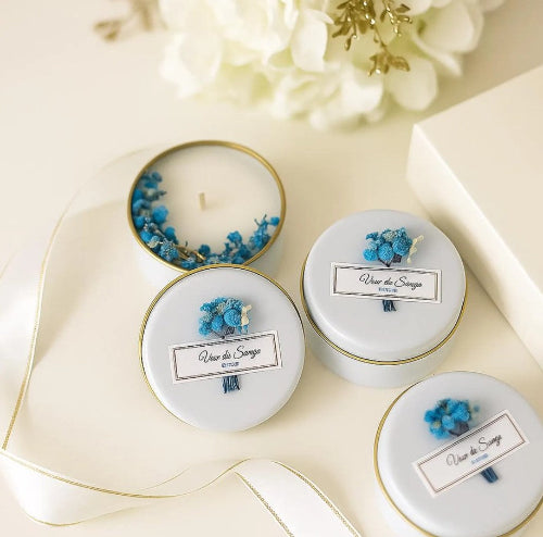 Set of small candles in white tins with decorative elements 