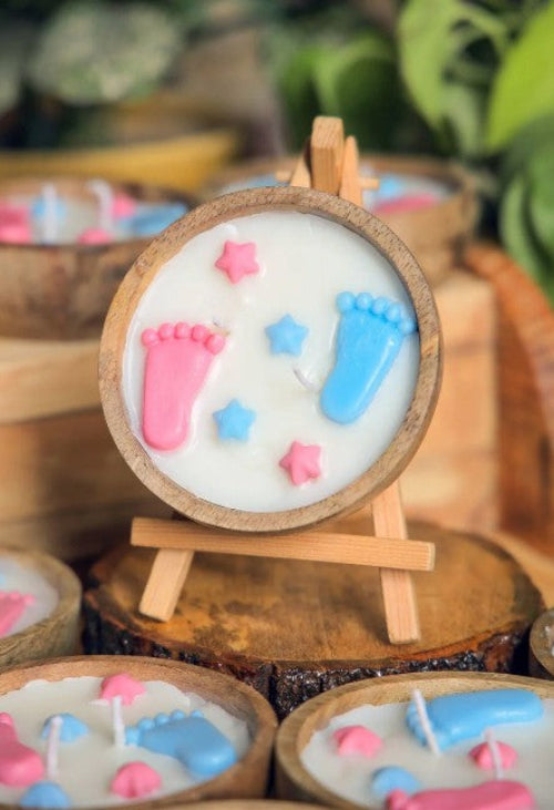 Decorative candles with footprints and stars on a wooden stand.