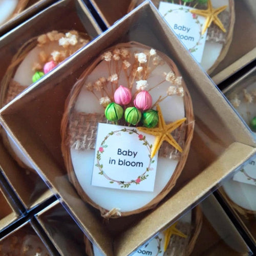 Decorative item with flowers and a star, labeled 'Baby in bloom', in a box.